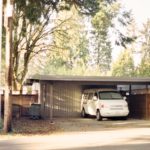 white car parked near brown wooden fence during daytime